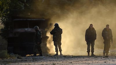 Ukrainian army soldiers check a burnt army truck on September 7, 2014 after an overnight bombing attack, at an Ukrainian army checkpoint in the outskirts of the key southeastern port city of Mariupol. Gunfire and heavy shelling raised fears that a tenuous truce between government and rebel forces may be on the brink of collapse. Philippe Desmazes/AFP Photo