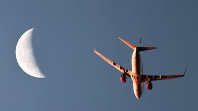 An Air Algerie airliner, with the moon seen in the background, flying above Marseille, south of France. AFP