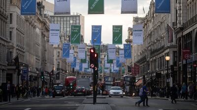 Banners advertising London's West End shopping district hang above shoppers along Regent Street in central London. Simon Dawson/Bloomberg