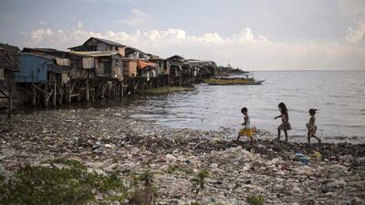 Children run along a rubbish-filled bay in Manila. About eight million tonnes of plastic waste are dumped into the world's oceans every year - the equivalent of one rubbish truck of plastic being tipped into the sea every minute of every day. Noel Celis / AFP