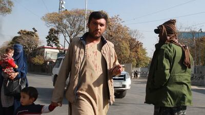 A man with blood stains on his shirt flees the scene of bomb blasts at Afghanistan's biggest military hospital in Kabul. At least 19 people were thought to have been killed, it was reported on Tuesday afternoon. EPA