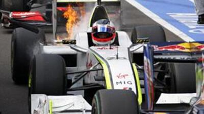 Rubens Barrichello, the Brazilian, drives in the pit lane with his engine on fire yesterday.