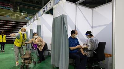 A nurse, right, prepares to administer a dose of the Pfizer-BioNTech Covid-19 vaccine inside the Incheon Samsan World Gymnasium in the Bupyeong district of Incheon, South Korea. Bloomberg