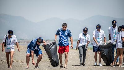 Greek wrestlers Archilleas Chrysidis and Christos Christoforidis (in blue) take part in a beach clean-up at the UWW Beach Wrestling World Series in Sarigerme, Turkey.