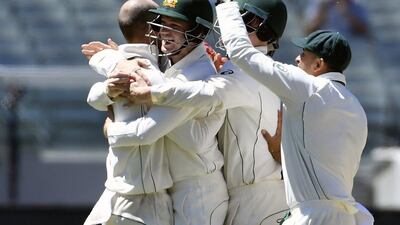 Australia’s Nathan Lyon, left, and Peter Handscomb celebrate capturing the wicket of Pakistan’s Asad Shafiq on the fifth day of their second Test in Melbourne, Australia, on December 30, 2016. Andy Brownbill / AP