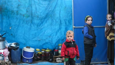 FILE PHOTO: Displaced Syrian children, who fled from southern Idlib, stand outside a tent in Afrin, Syria February 6, 2020. Picture taken February 6, 2020. REUTERS/Khalil Ashawi/File Photo