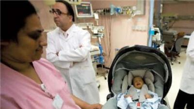 Dr Taisser Atrak, the chairman of Paediatrics at Mafraq Hospital, rear left, started a programme earlier this year to ensure new babies leave hospital in safety seats. The hospital has given away 550 seats to date.