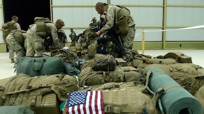 US Marines arrange their equipment as US troops arrive in Kandahar after their withdrawl from the Camp Bastion-Leatherneck complex in Helmand province on October 26, 2014. AFP