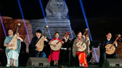 In this picture taken on April 3, 2023, members of the China National Traditional Orchestra perform during a concert on the plateau of the Great Pyramids of Giza on the outskirts of Cairo. (Photo by Khaled DESOUKI / AFP)