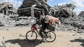 A man rides a bicycle with his belongings in Khan Younis. Gazans are turning to two wheels to carry food, transport patients, check on family and escape danger. Getty Images
