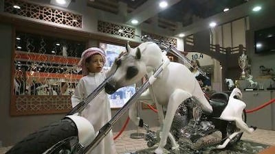 Visitors look at the motorbike designed in the form of a horse on the opening day of the Abu Dhabi International Hunting and Equestrain Exhibition yesterday at Abu Dhabi National Exhibition Centre. Ravindranath K / The National