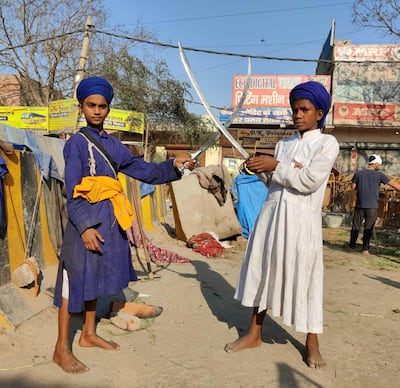 Fatesh Singh, 14, left, and Son Singh, 15, practise swordsmanship. The boys are members of the ancient Sikh Nihang warrior order that is protecting an Indian farmers' protest camp near New Delhi. Taniya Dutta for The National