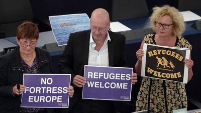 Members of European Parliament hold banners reading 'no fortress Europe' during a debate on the unprecedented flow of migrants and refugees at the European Parliament in Strasbourg, eastern France, on September 9, 2015. European Commission chief Jean-Claude Juncker released plans to force the bloc to share 160,000 refugees and ease the pressure on border states from the worst migration crisis since the Second World War II. Frederick Florin / AFP Photo
