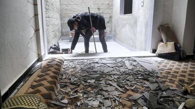 A man cleaning debris at his home after an Israeli air strike, south of the Syrian capital Damascus. AFP