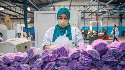 A factory worker packages disposable protective masks along a production line in Morocco's Casablanca. AFP
