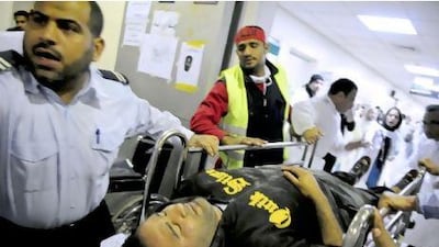 A man from the Shiite Muslim village of Sitra is wheeled into the Salmaniya hospital after he was shot with buckshot, as the king imposed a state of emergency after bringing in foreign troops to help quell demonstrations.