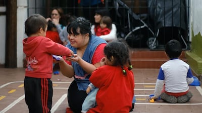 Kindergarten teacher Noelia Garella, centre, who was born with Down Syndrome, plays with children at the Jeromito kindergarten in Cordoba, Argentina on September 29, 2016 where she teaches. Diego Lima / AFP