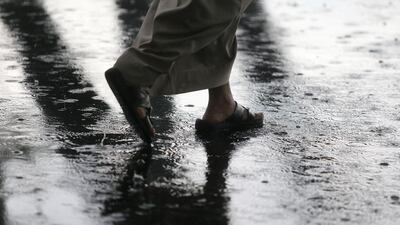 A man braves the water collecting on the ground during a rainstorm in Abu Dhabi. Delores Johnson / The National