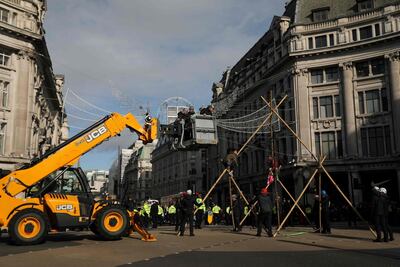 Police use heavy machinery as they remove a climate activist perched on a makeshift structure in Oxford Street. AFP