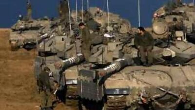 Israeli soldiers prepare their tanks as they take positions on the northern border of the Gaza Strip.