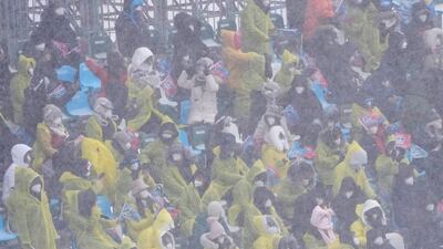 Spectators watch during the mixed team snowboard cross finals as the snow falls at the 2022 Beijing Winter Olympics. AP Photo