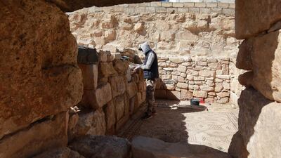 A worker restores a stone wall at the ancient church complex in Rihab, Jordan. Workers earn between 12.5 Jordanian dinars ($18) and 15 Jordanian dinars a day. AFP