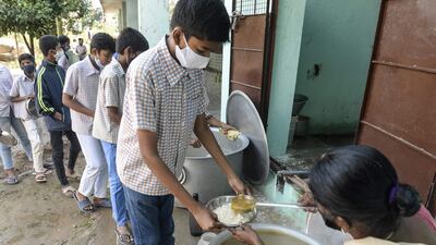 Staff serve midday meals to pupils at a government high school on the outskirts of Hyderabad in India, as schools reopened after months closed due to the Covid-19 pandemic. AFP