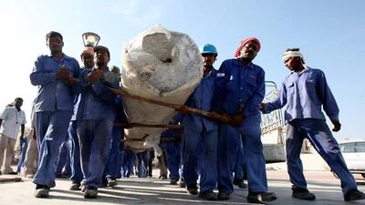 Workers carry the carpet roll at the Al Farooq mosque in Al Safa area in Dubai.