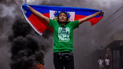 A women holds a Haitian flag during a protest against gang violence and the government's failure to contain it, in Port-au-Prince. EPA