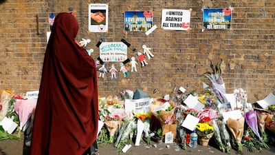 A woman looks at tributes placed for the victims of a vehicle ramming attack near a mosque in Finsbury Park, north London, on June 19, 2017. AFP