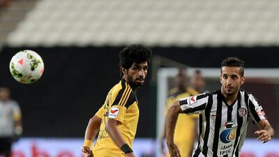 Al Jazira's Ali Mabkhout, right, and Kalba's Khaled Ali Khamis tussel for the ball in the Arabian Gulf League match at Mohammad bin Zayed Stadium in Abu Dhabi. Ravindranath K / The National