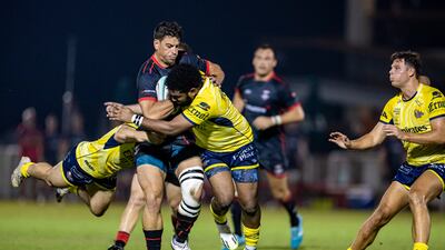 Justin Walsh of Dubai Exiles is tackled by Sefa Waqa and Eremia Tapsell of Dubai Hurricanes.