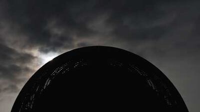 The wooden Globe building is seen in silhouette at sunrise at the entrance of the European Organization for Nuclear Research (CERN) offices, where scientists believe they have found the Higgs boson.