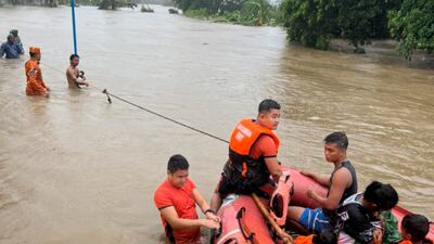 Rescuers evacuate residents to higher ground in Bacarra, in the northern Philippines. AP