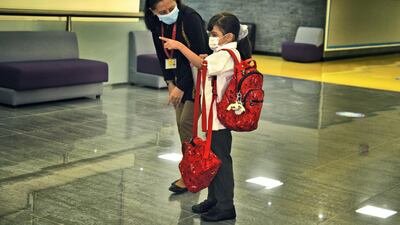 A staff member assists a pupil as Al Mizhar American Academy. Shruti Jain for The National