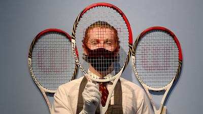 A Christie's employee poses with Swiss tennis Roger Federer's racket used at the London Olympics 2012 at Christie's in London last month during a live auction.
