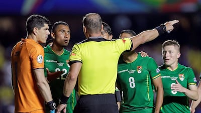 Bolivia goalkeeper Carlos Lampe, left, and Adrian Jusino protest with referee Nestor Pitana after Pitana awarded a penalty to Brazil. EPA