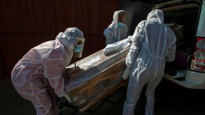 Funeral home workers in protective suits carry the coffin of a woman who died from COVID-19 into a hearse in Katlehong, near Johannesburg, South Africa, July 21 2020. AP Photo