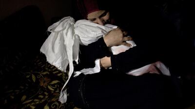 Netream Netzleam holds the body of her baby daughter Razel who died from injuries sustained in an air raid, as she bids farewell before her burial in Rafah in the southern Gaza Strip. It was my 10th day covering the war in Gaza and before even 11am, I had been to the morgue in northern Gaza to photograph an Iman whose job is to prepare the bodies for burial. I was on assignment to photograph him preparing a body but the family came to the hospital and took their dead family member away. I knew that there would be others, if not that day, then the next. Before arriving to Rafa, we stopped in the morgue in Khan Younis which was overflowing with the victims who had been killed by Israeli air attacks overnight. Going to the morgue each morning became part of our early morning routine and it was in the morgue in Khan Younis that we learnt about the death of Razel – her life was stopped before she ever learnt to walk. When we arrived at the European Hospital in Rafa, her body was just beginning to be wrapped in the white cotton cloth. It took only a few seconds for the pristine white cotton cloth to be soaked by blood. Her father carried her body into the car and we followed him to his home. Razel’s body was first placed on the sofa where her mother Netream leaned over and stroked her face. She picked up the body of her lifeless body and wept before the men placed her on a tiny prayer carpet and prayed. The man who lead the prayer was forced to sit because of his own injuries.