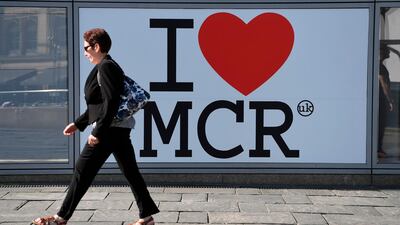 A pedestrian walks past a sign of support for Manchester. AFP/Paul ELLIS