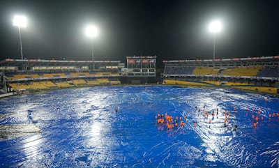 Ground staff stand on the covered field after rain interrupted the Asia Cup match between India and Pakistan. AP