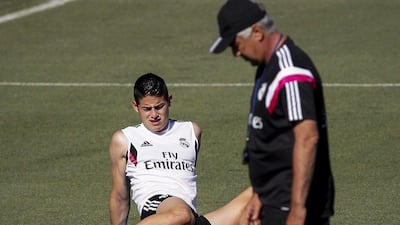 Real Madrid forward James Rodriguez, left, warms up next to Italian head coach Carlo Ancelotti during their team's training session in the Sport City of Valdebebas in Madrid, Spain, on August 8, 2014. EPA/EMILIO NARANJO