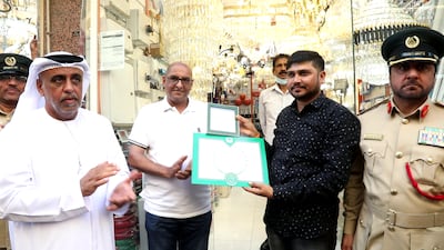 Dubai Police CID chief Ibrahim Al Mansouri, left, pictured with Keshur Karu Chavda, centre right, and his shop manager, Nilesh Megchiani, centre, after foiling a Dh2.7m theft. Photo: Dubai Police