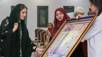 Sayyida Al Busaidiyah receives a gift during a visit to Al Rustaq care home. AFP