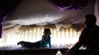 A Syrian father and daughter from the city of Homs watch a television in their tent inside of a camp for Syrians who have fled the fighting in their country in Baalbek, Lebanon. Spencer Platt / Getty Images
