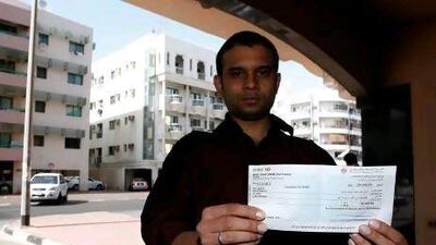 Amanullah Jamal holds the cheque from the Government of Sharjah that will help him and his family rebuild after fire gutted their apartment in Al Baker 4 Tower last month.