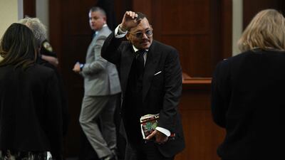 Depp gestures to his fans in the courtroom. AFP