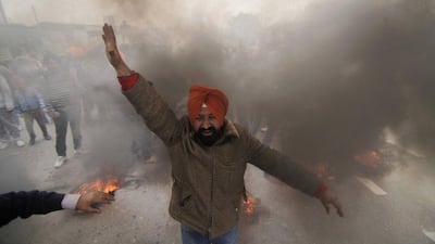 A Sikh protester shouts slogans as dozens of others burn tires during a protest against Congress party leader Rahul Gandhi for his recent remark on the country’s 1984 anti-Sikh riots, in Jammu, India. India has blocked the release of a film on the assassination of former Indian prime minister Indira Gandhi, Rahul’s grandmother, saying it glorifies her killers and could trigger violent protests. Channi Anand / AP Photo / File