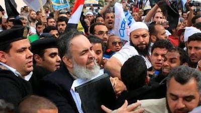 The Egyptian Salafist presidential candidate Hazem Abu Ismail is surrounded by security guards and hundreds of his supporters during a rally yesterday outside a Cairo courtroom.