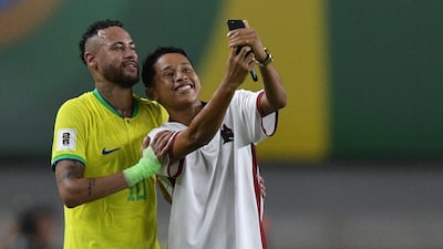 Brazil's Neymar poses for a selfie with a fan who ran into the pitch during the World Cup qualifier against Bolivia. AFP